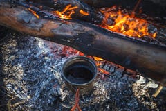 Metal Cup with tea is heated from the campfire in winter stock photo Metal Cup with tea is heated from the campfire in winter stock photo
