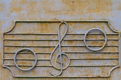 Metal fence of the old music school with decorative symbols in the form of a treble clef and notes on the stave
