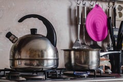 Metal il bollitore ed il vaso su una stufa di gas bruciante immagini stock Metal il bollitore ed il vaso su una stufa di gas bruciante immagini stock