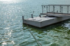 Metal le pilier de bateau, sur un lac vert de l'eau, le soleil miroitant sur petit W image stock Metal le pilier de bateau, sur un lac vert de l'eau, le soleil miroitant sur petit W image stock