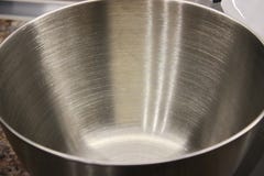 Metallbunke för att laga mat, cookware blandande produkter i en stor bunke, en platta för en planetarisk matberedare arkivbild Metallbunke för att laga mat, cookware blandande produkter i en stor bunke, en platta för en planetarisk matberedare arkivbild