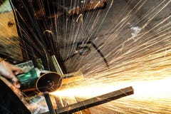 Metallo di taglio dell'operaio con la smerigliatrice Scintilla mentre frantumano il ferro fotografia stock libera da diritti Metallo di taglio dell'operaio con la smerigliatrice Scintilla mentre frantumano il ferro fotografia stock libera da diritti