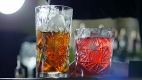 Metalu baru łyżkowe mieszanki zamrażają od whisky w szkle na unfocused tle zbiory wideo Metalu baru łyżkowe mieszanki zamrażają od whisky w szkle na unfocused tle zbiory wideo