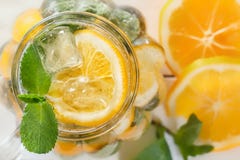 Metselaarkruik een eigengemaakte limonade met munt en ijs, citrusvruchtenplakken op een rustieke witte houten achtergrond royalty-vrije stock afbeeldingen Metselaarkruik een eigengemaakte limonade met munt en ijs, citrusvruchtenplakken op een rustieke witte houten achtergrond royalty-vrije stock afbeeldingen