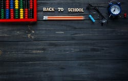 Metta di cancelleria sui precedenti di legno grigi Punteggi, vetri rotondi, matite, sveglia Di nuovo alla scuola, istruzione fotografia stock Metta di cancelleria sui precedenti di legno grigi Punteggi, vetri rotondi, matite, sveglia Di nuovo alla scuola, istruzione fotografia stock