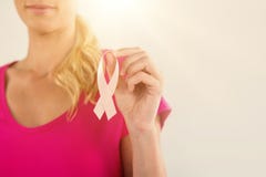 Metà di sezione della donna che tiene il nastro rosa di consapevolezza del cancro al seno immagine stock Metà di sezione della donna che tiene il nastro rosa di consapevolezza del cancro al seno immagine stock