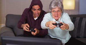 Mexicansk grabb som spelar videospel med mormodern royaltyfria foton Mexicansk grabb som spelar videospel med mormodern royaltyfria foton