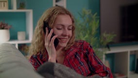 Middel dat van Oman wordt geschoten die een smartphone op een bank in comfortabele woonkamer uitnodigen stock video Middel dat van Oman wordt geschoten die een smartphone op een bank in comfortabele woonkamer uitnodigen stock video