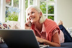 Midden Oude Vrouw die tot Punt op Telefoon opdracht geven stock foto Midden Oude Vrouw die tot Punt op Telefoon opdracht geven stock foto