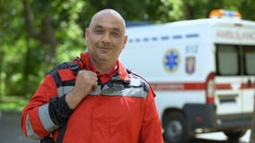 Middle-aged paramedic posing for camera, professional emergency medical service