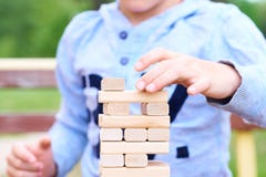 Middle section of the kid playing wood blocks tower game for practicing physical and mental skill. royalty free stock photography Middle section of the kid playing wood blocks tower game for practicing physical and mental skill. royalty free stock photography