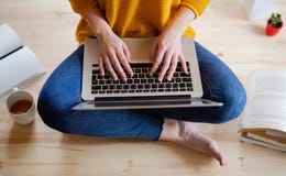 A midsection of female student sitting on floor using laptop when studying. royalty free stock photos A midsection of female student sitting on floor using laptop when studying. royalty free stock photos