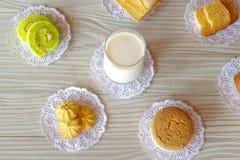 Milch-Butterbrot-Kuchen-Rollenplätzchen und Knoblauch-Brot des kleinen Kuchens auf weißem Holztisch lizenzfreies stockbild Milch-Butterbrot-Kuchen-Rollenplätzchen und Knoblauch-Brot des kleinen Kuchens auf weißem Holztisch lizenzfreies stockbild