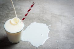 Milk pouring into glass on a concrete table royalty free stock photography Milk pouring into glass on a concrete table royalty free stock photography