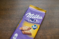 Milkachocoladereep met Tuc-cracker met houten achtergrond Milka is een merk van chocoladegebak door Internationale MondelÄ „z stock fotografie Milkachocoladereep met Tuc-cracker met houten achtergrond Milka is een merk van chocoladegebak door Internationale MondelÄ „z stock fotografie