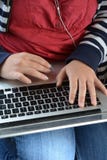 Millennial woman using a laptop computer and earphones royalty free stock photography Millennial woman using a laptop computer and earphones royalty free stock photography