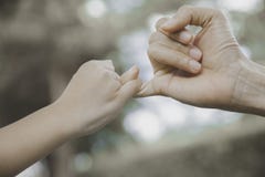 Mime y su niño que engancha sus fingeres para hacer una promesa foto de archivo libre de regalías Mime y su niño que engancha sus fingeres para hacer una promesa foto de archivo libre de regalías