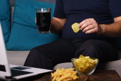 Mindless snacking och att äta för mycket, brist av fysisk aktivitet arkivfoton Mindless snacking och att äta för mycket, brist av fysisk aktivitet arkivfoton