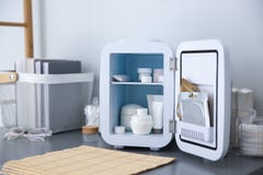 Mini Fridge With Cosmetic Products On Grey Vanity Table Indoors Royalty Free Stock Image