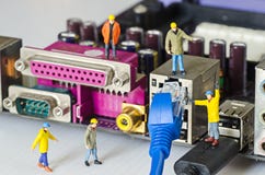 Miniature engineer team try to connect ethernet cables to port Stock Photography Miniature engineer team try to connect ethernet cables to port Stock Photography