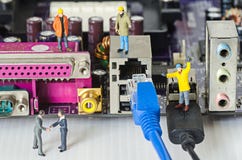 Miniature engineer team try to connect ethernet cables to port Royalty Free Stock Image Miniature engineer team try to connect ethernet cables to port Royalty Free Stock Image
