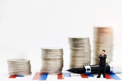 Miniature people: Businessman standing on graph with looking royalty free stock photos Miniature people: Businessman standing on graph with looking royalty free stock photos