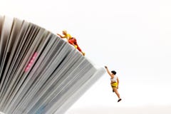 Miniature people climbing book with challenging route on cliff Royalty Free Stock Photography Miniature people climbing book with challenging route on cliff Royalty Free Stock Photography