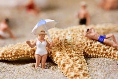 Miniature people in swimsuit on the beach royalty free stock image Miniature people in swimsuit on the beach royalty free stock image