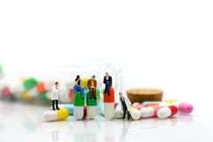 Miniatuurmensen: arts en geduldige tribune met drug, pillen, capsu royalty-vrije stock foto Miniatuurmensen: arts en geduldige tribune met drug, pillen, capsu royalty-vrije stock foto