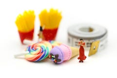 Miniatuurmensen: mooie vrouwenzitting bij het meetlint met royalty-vrije stock foto Miniatuurmensen: mooie vrouwenzitting bij het meetlint met royalty-vrije stock foto