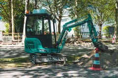 Minigraafwerktuig, die aan de weg werken Amsterdam Buitenveldert stock afbeelding Minigraafwerktuig, die aan de weg werken Amsterdam Buitenveldert stock afbeelding