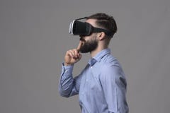 Minimalism profile view of young business man wearing vr glasses with finger over lips looking away at copyspace Stock Photo Minimalism profile view of young business man wearing vr glasses with finger over lips looking away at copyspace Stock Photo