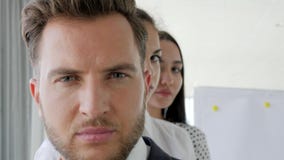 Mirada seria del líder con los colaboradores, cara del negocio, retrato de los hombres de negocios que se colocan en fila en ofic Mirada seria del líder con los colaboradores, cara del negocio, retrato de los hombres de negocios que se colocan en fila en ofic