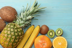 miscela della noce di cocco, della banana, del kiwi, dell'arancia e dell'ananas freschi su fondo di legno blu Vista superiore con fotografia stock libera da diritti miscela della noce di cocco, della banana, del kiwi, dell'arancia e dell'ananas freschi su fondo di legno blu Vista superiore con fotografia stock libera da diritti