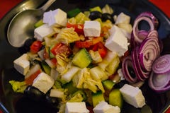 Misture a salada das folhas com a pimenta roasted e descascada do tomate, de sino, e o queijo de feta vestido com azeite, alho, e fotografia de stock royalty free Misture a salada das folhas com a pimenta roasted e descascada do tomate, de sino, e o queijo de feta vestido com azeite, alho, e fotografia de stock royalty free