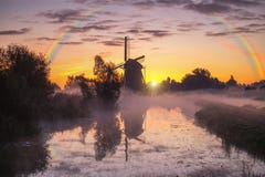 Misty and rainy windmill warm sunrise