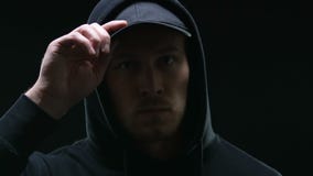 Mit Kapuze Gruppenmitglied, das bedrohlich die Kamera, geistlich bereitend für Verbrechen untersucht vor stock footage Mit Kapuze Gruppenmitglied, das bedrohlich die Kamera, geistlich bereitend für Verbrechen untersucht vor stock footage