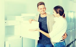 Mittelstandfamilienpaare, die neuen Kühlschrank wählen lizenzfreies stockfoto Mittelstandfamilienpaare, die neuen Kühlschrank wählen lizenzfreies stockfoto