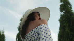 Mittlere Greisin in einem Kleid und weißen in einem Sonnenhut schaut herum und genießt den sonnigen Tag stock video footage Mittlere Greisin in einem Kleid und weißen in einem Sonnenhut schaut herum und genießt den sonnigen Tag stock video footage
