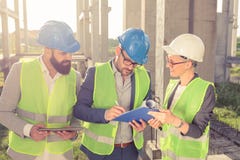 Group of architects or business partners having a meeting and signing documents on a construction site royalty free stock photography Group of architects or business partners having a meeting and signing documents on a construction site royalty free stock photography