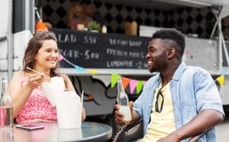 Mixed race couple eating and talking at food truck Royalty Free Stock Photo Mixed race couple eating and talking at food truck Royalty Free Stock Photo