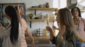 Mixed race group of 5 women friends having fun in the kitchen. girls drink champagne and dance 4K