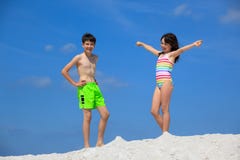 Miúdos em ternos de banho na praia fotografia de stock Miúdos em ternos de banho na praia fotografia de stock