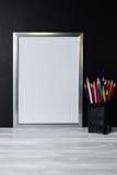 Mock up white frame and colored pencils on wooden shelf and blackboard royalty free stock photo Mock up white frame and colored pencils on wooden shelf and blackboard royalty free stock photo