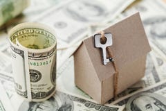 Model cardboard home, key and dollar money. House building, insurance, housewarming, loan, real estate, cost of housing, buying