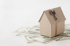 Model van kartonhuis met sleutel en dollarrekeningen Woningbouw, onroerende goederen lening, kosten om een nieuw huis te huisvest Stock Afbeelding Model van kartonhuis met sleutel en dollarrekeningen Woningbouw, onroerende goederen lening, kosten om een nieuw huis te huisvest Stock Afbeelding