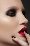 Modele con maquillaje de la manera, la manicura y los labios vinosos imagen de archivo Modele con maquillaje de la manera, la manicura y los labios vinosos imagen de archivo