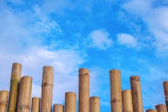 Modelli di bambù del recinto e cielo blu vivo con il fondo delle nuvole fotografia stock Modelli di bambù del recinto e cielo blu vivo con il fondo delle nuvole fotografia stock