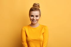 Modello femminile attactive splendido che posa al camear sopra fondo giallo fotografie stock Modello femminile attactive splendido che posa al camear sopra fondo giallo fotografie stock