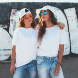 Models wearing plain tshirt and sunglasses posing over street wa